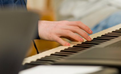 Student s hand playing a piano