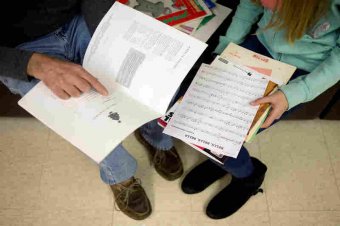 Major Chords for Minors instructor Bruce Leaman (left) and Paige Rosas, 12, look through music books to find some songs for Rosas to practice with during her piano lesson.